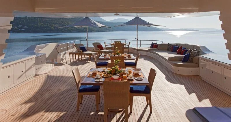 a lounge area with a table and chairs and an umbrella aboard MARY-JEAN II Yacht for Sale