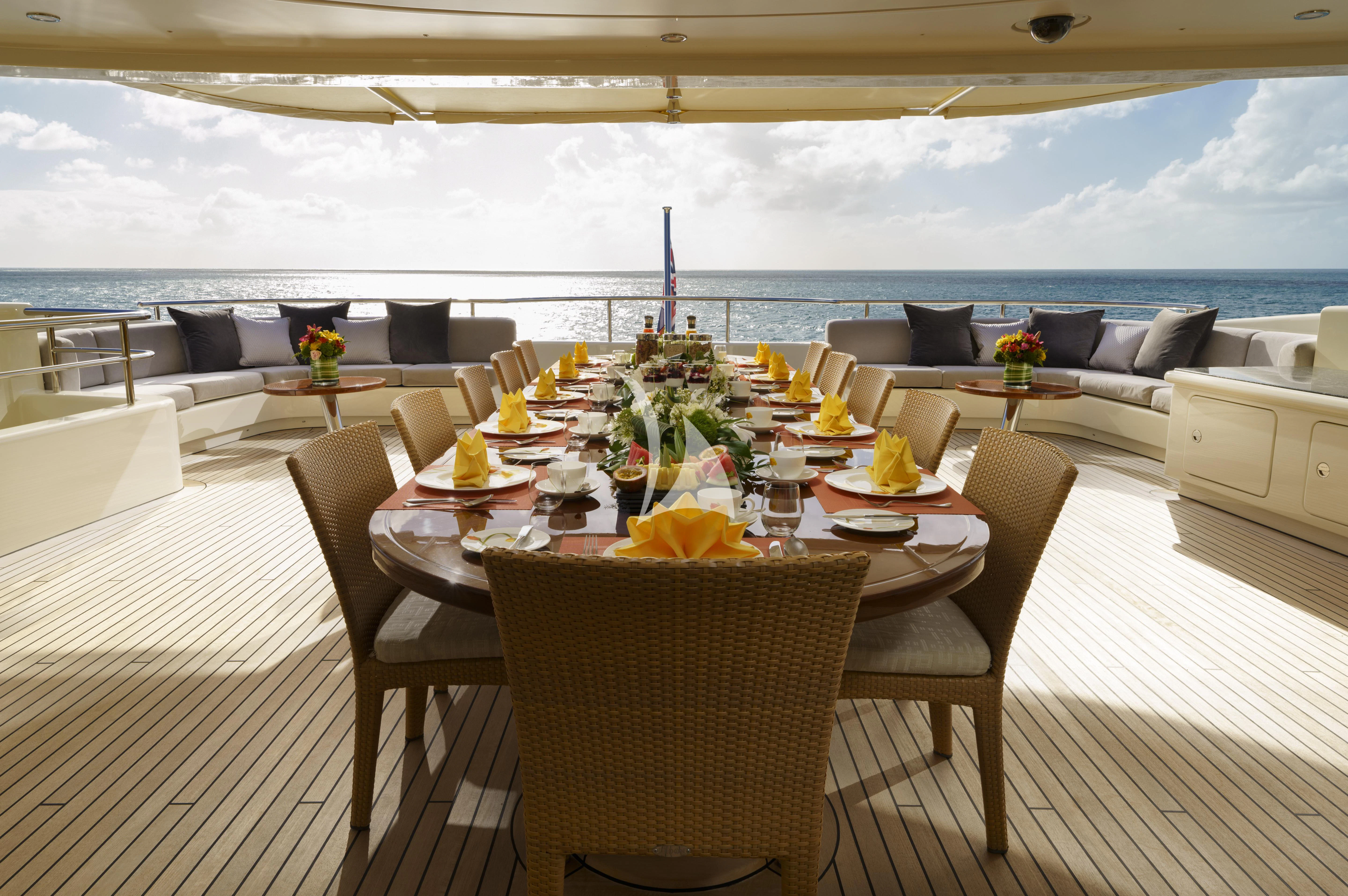 a table set for a meal on a deck overlooking the ocean aboard MARY-JEAN II Yacht for Sale