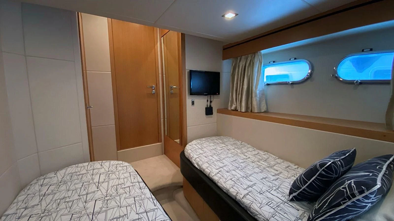 a room with a bed and a television aboard LIO Yacht for Sale