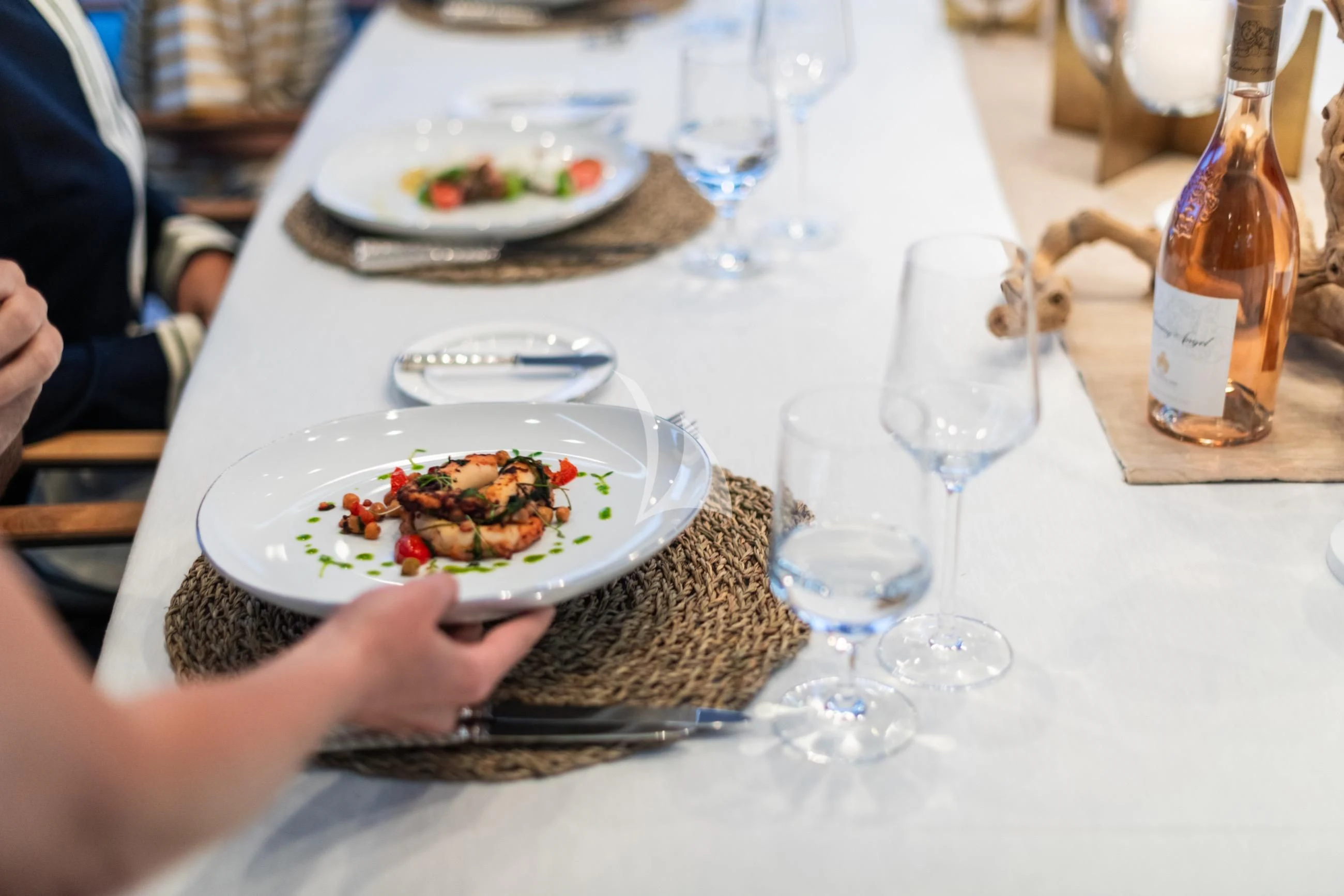 a table with plates of food and wine glasses aboard HOLDIN' MY OWN Yacht for Sale