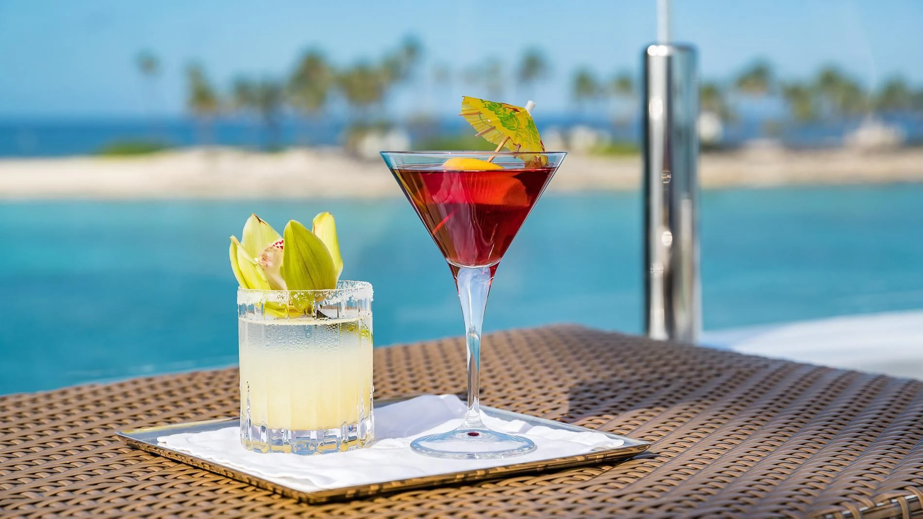 a couple of glasses with drinks on a table with a view of the water and a city in aboard HOLDIN' MY OWN Yacht for Sale