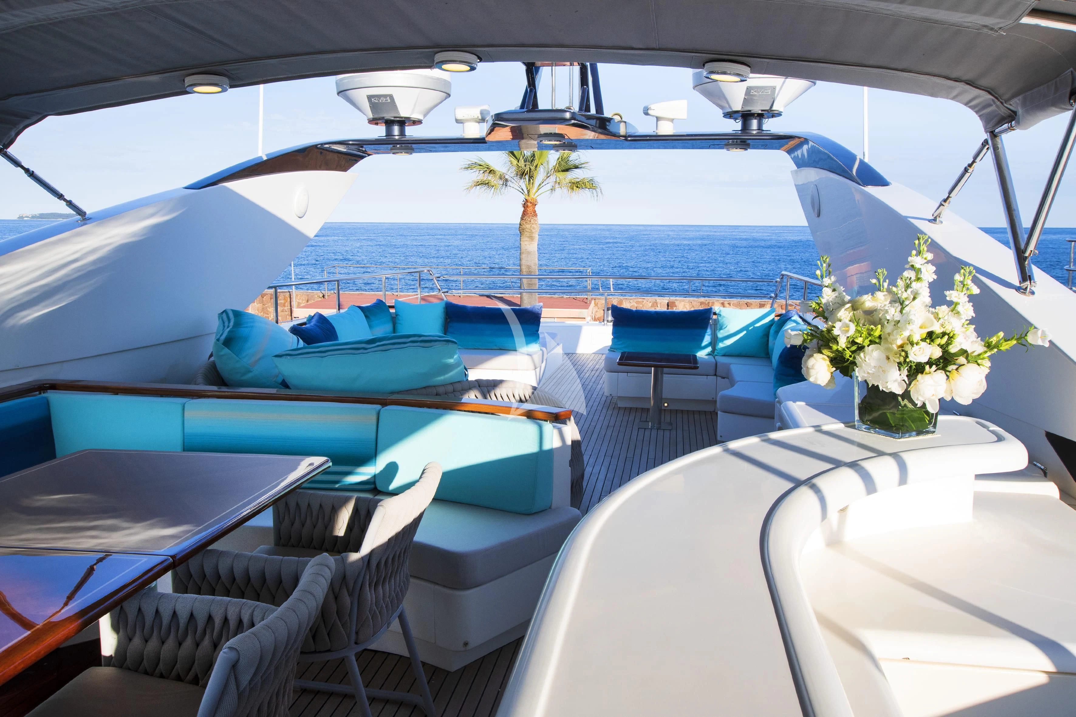a boat with a large blue body of water and a table with chairs aboard LADY EMMA Yacht for Sale
