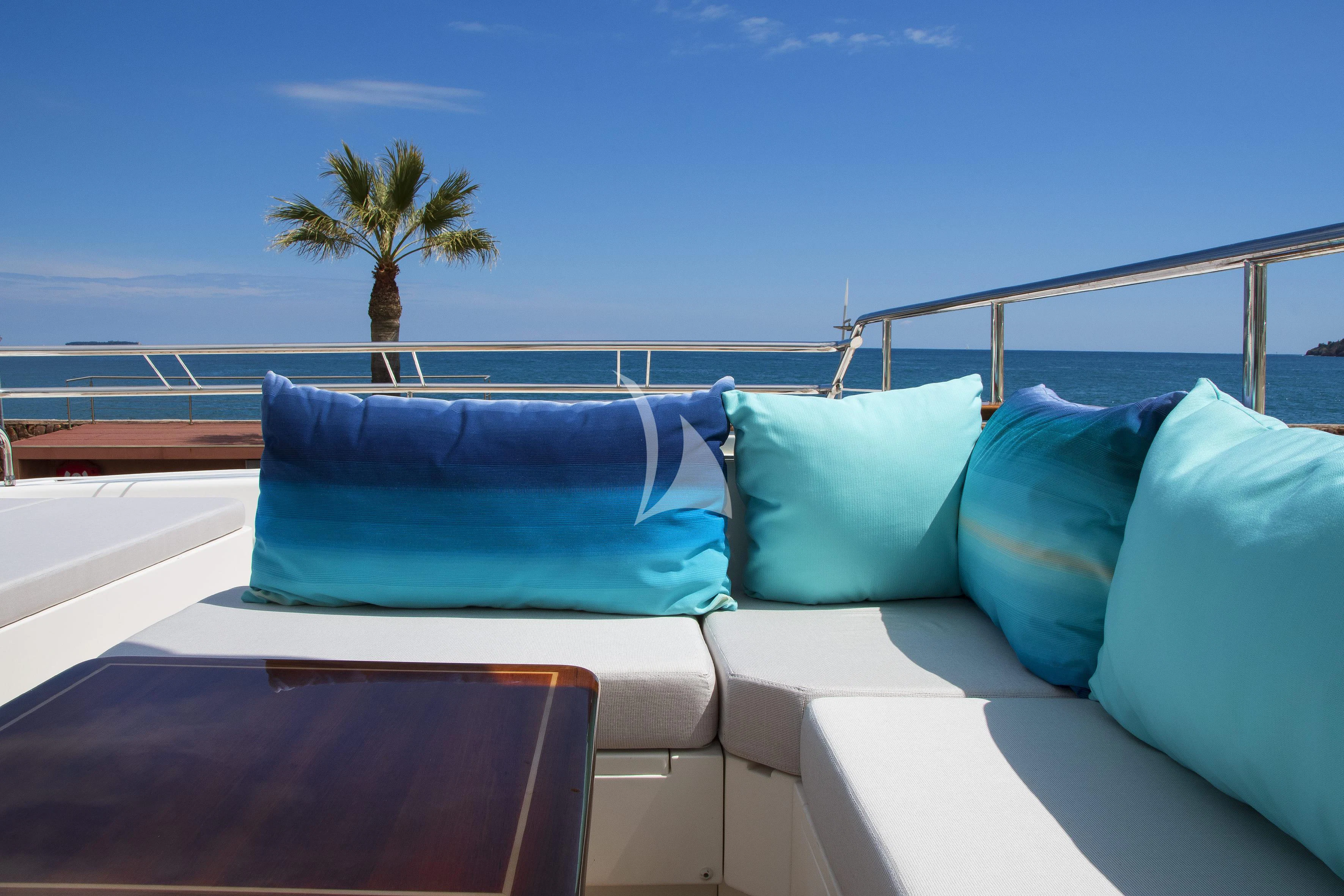 a bed with pillows and a palm tree on the side aboard LADY EMMA Yacht for Sale
