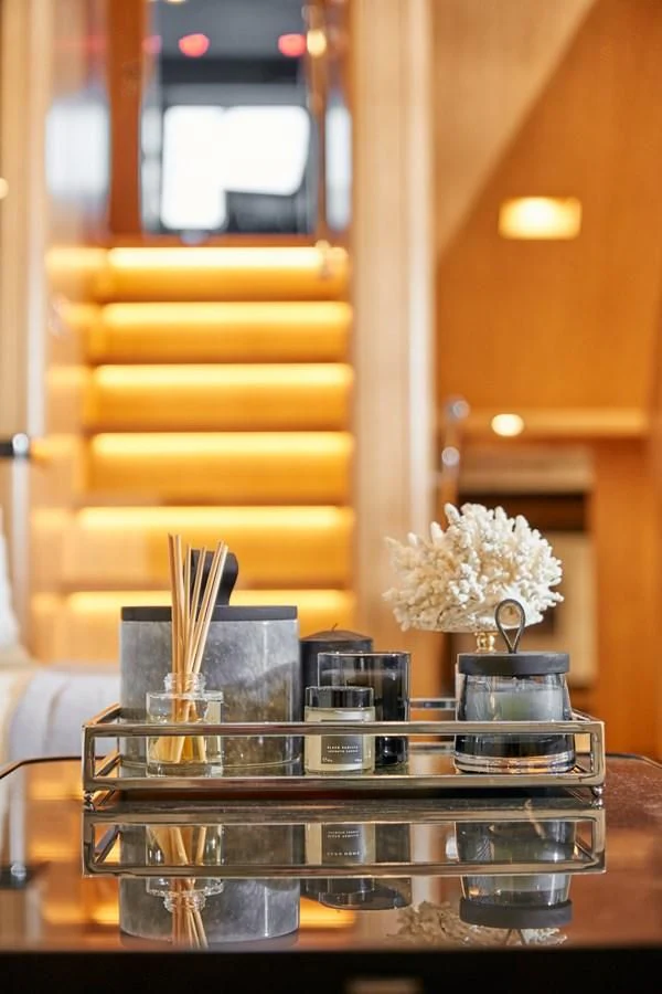 a glass table with a glass and a vase with flowers on it aboard BERING 88/05 Yacht for Sale