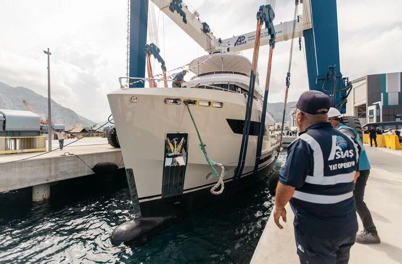 a man standing next to a boat aboard BERING 88/05 Yacht for Sale