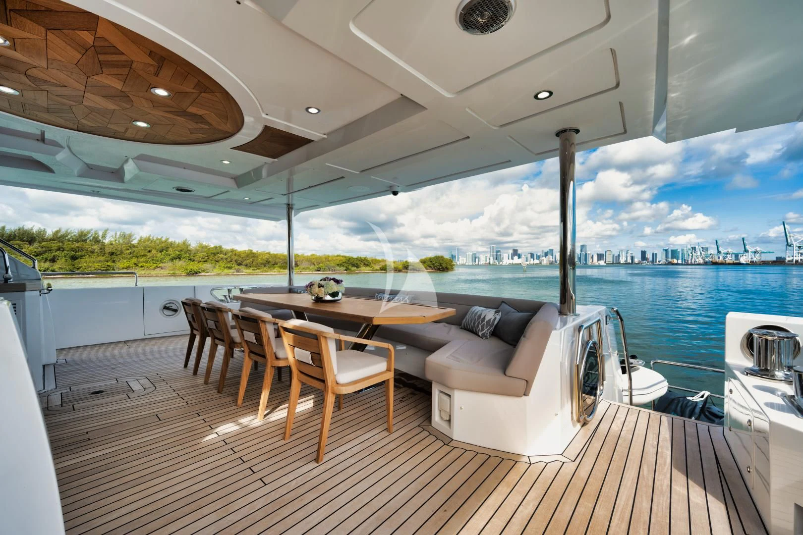 a large open area with a table and chairs and a large body of water aboard PERSISTENCE Yacht for Sale