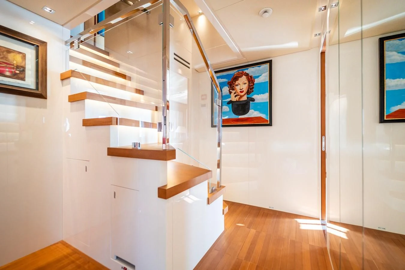 a staircase in a room with paintings on the wall aboard BLUES Yacht for Sale