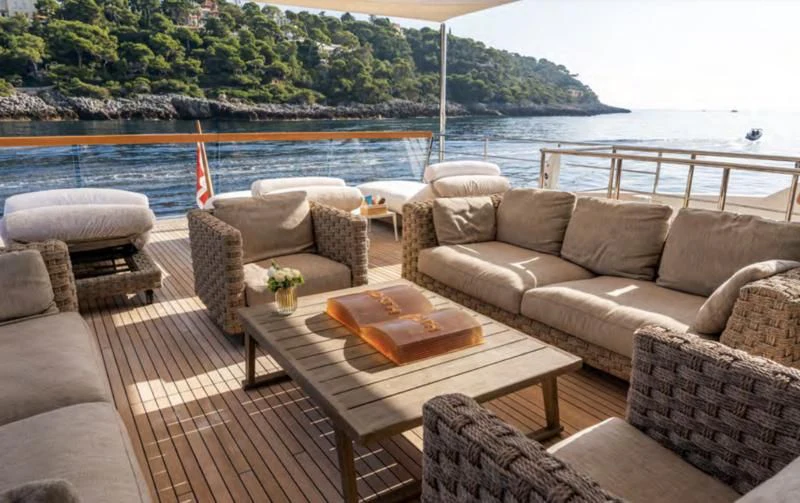 a couch and a table on a deck overlooking a body of water aboard BLUES Yacht for Sale