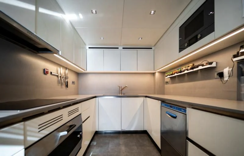 a kitchen with white cabinets aboard BLUES Yacht for Sale