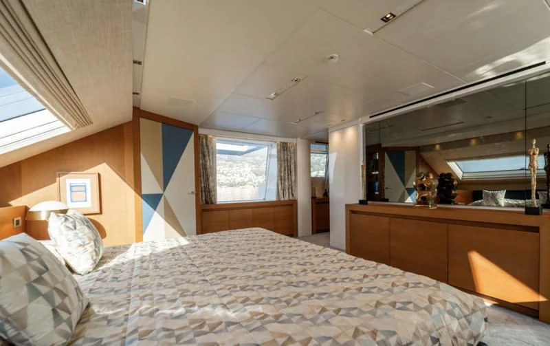 a bedroom with a bed and a piano aboard BLUES Yacht for Sale