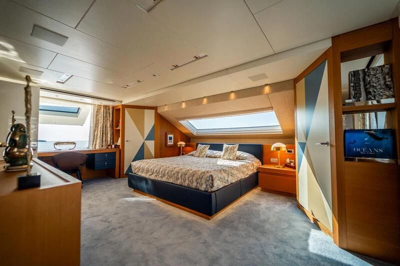 a bedroom with a bed and desk aboard BLUES Yacht for Sale