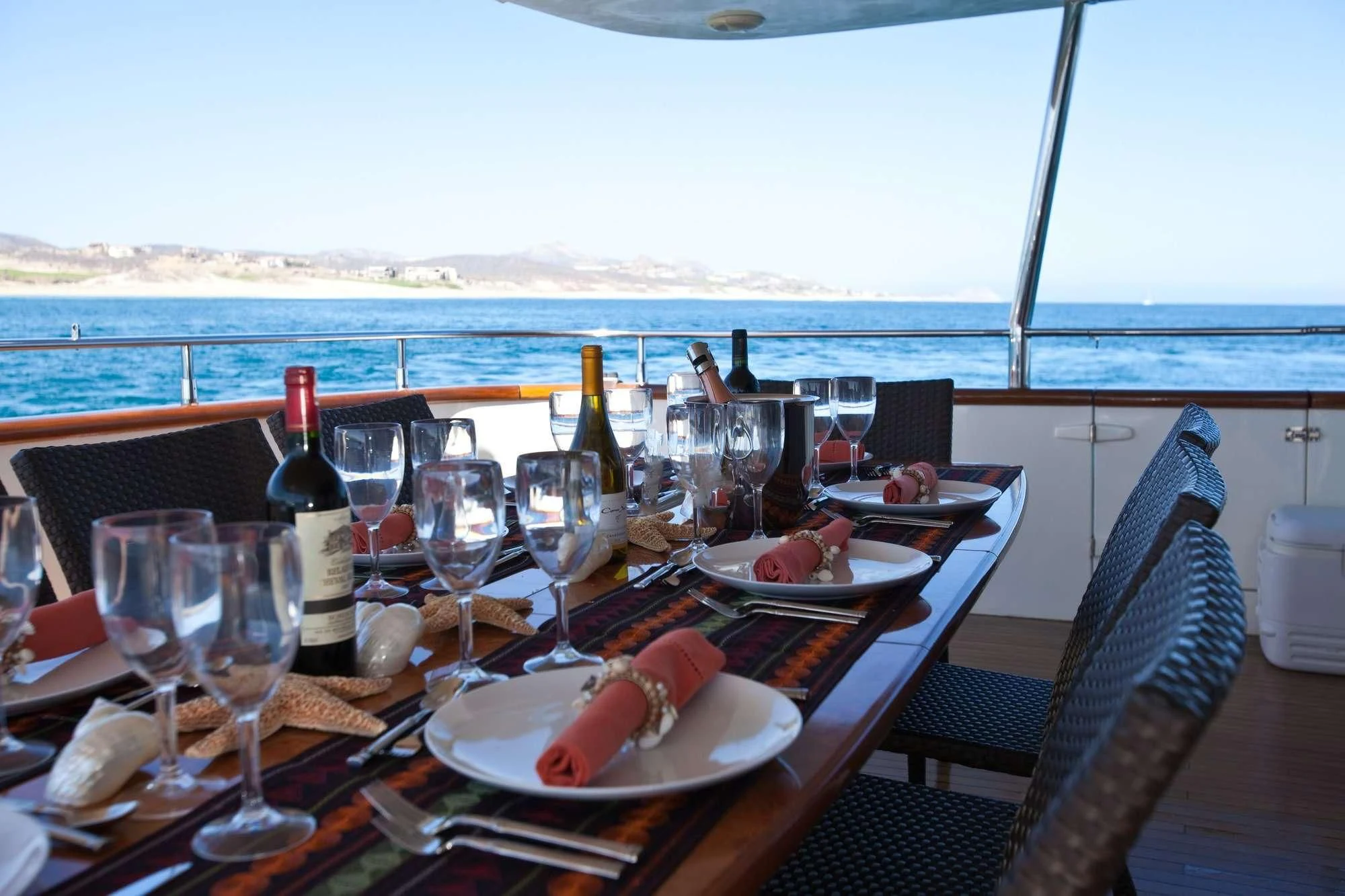 a table with wine glasses and food on it aboard SUPER Yacht for Charter