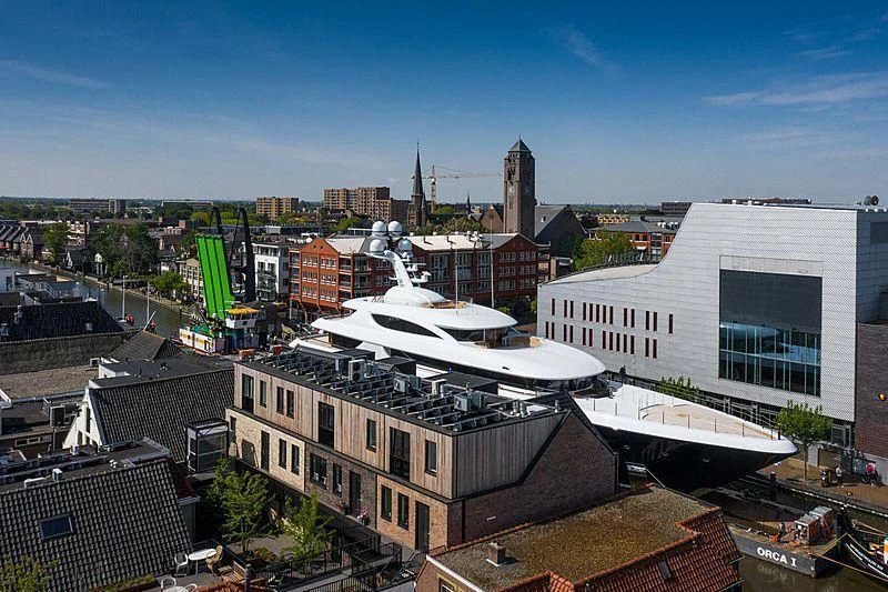 a large white boat in a city aboard PODIUM Yacht for Sale