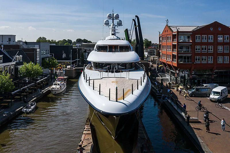 a large white boat docked at a pier aboard PODIUM Yacht for Sale