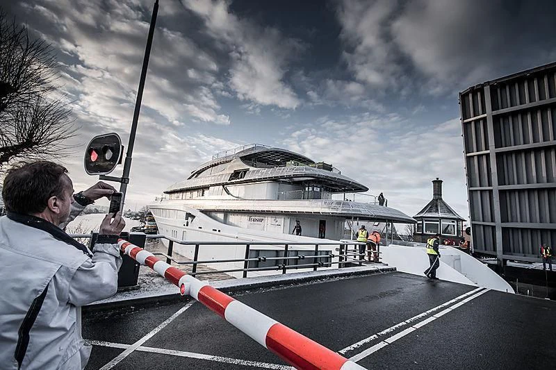 a man holding a pole with a building in the background aboard PODIUM Yacht for Sale