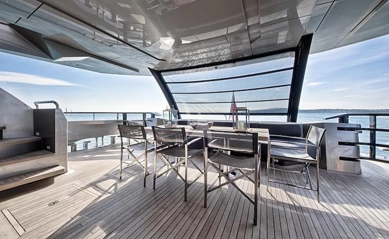 a deck with a table and chairs aboard FUSION Yacht for Charter