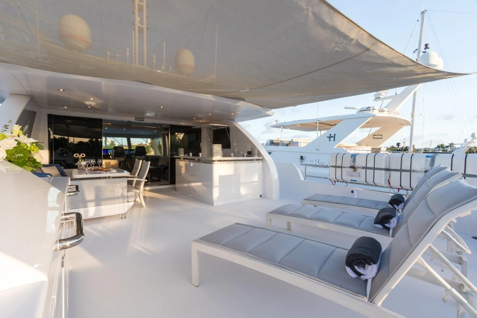 a room with a row of white tables and chairs aboard GG Yacht for Sale