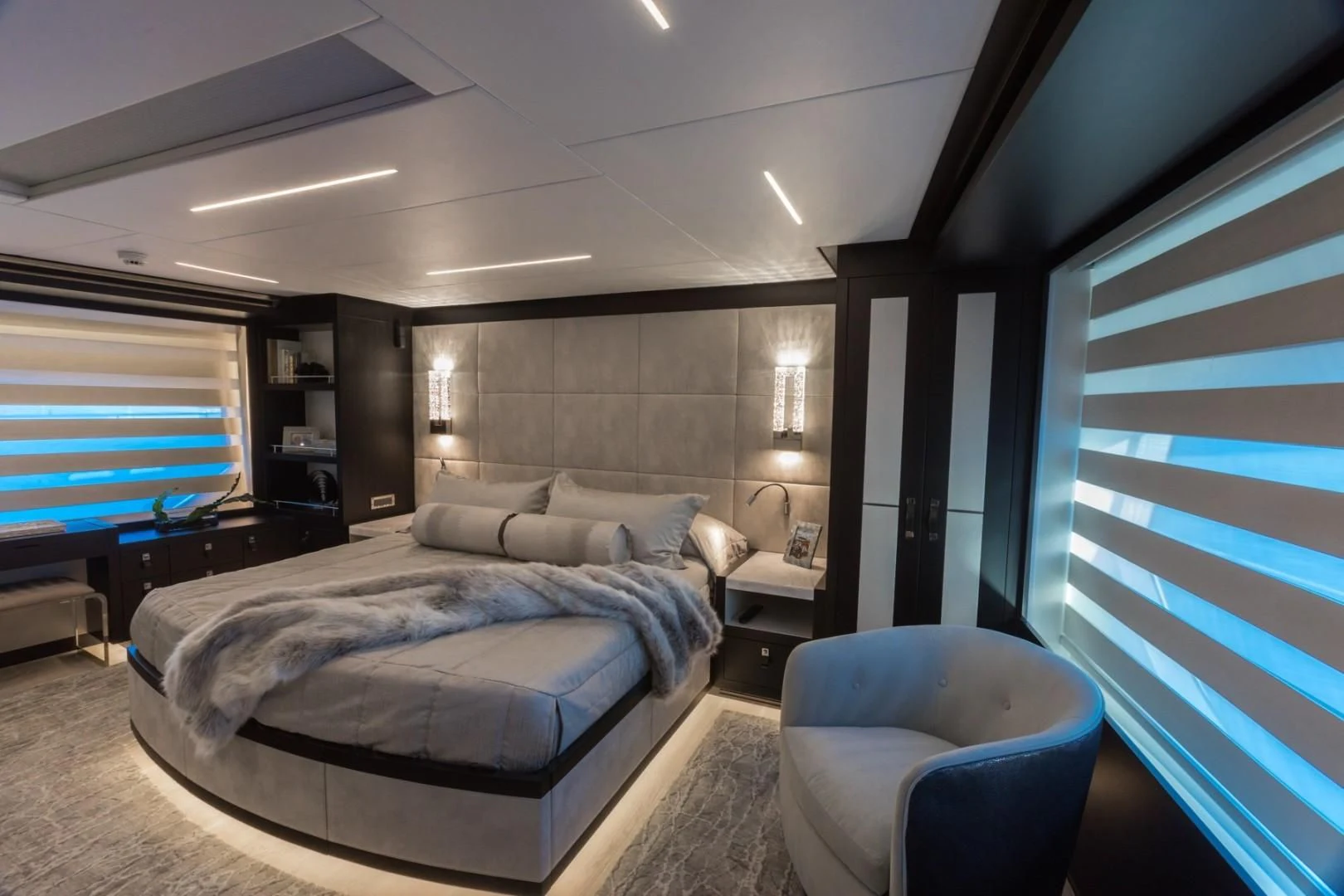a bedroom with a bed and a chair aboard GG Yacht for Sale
