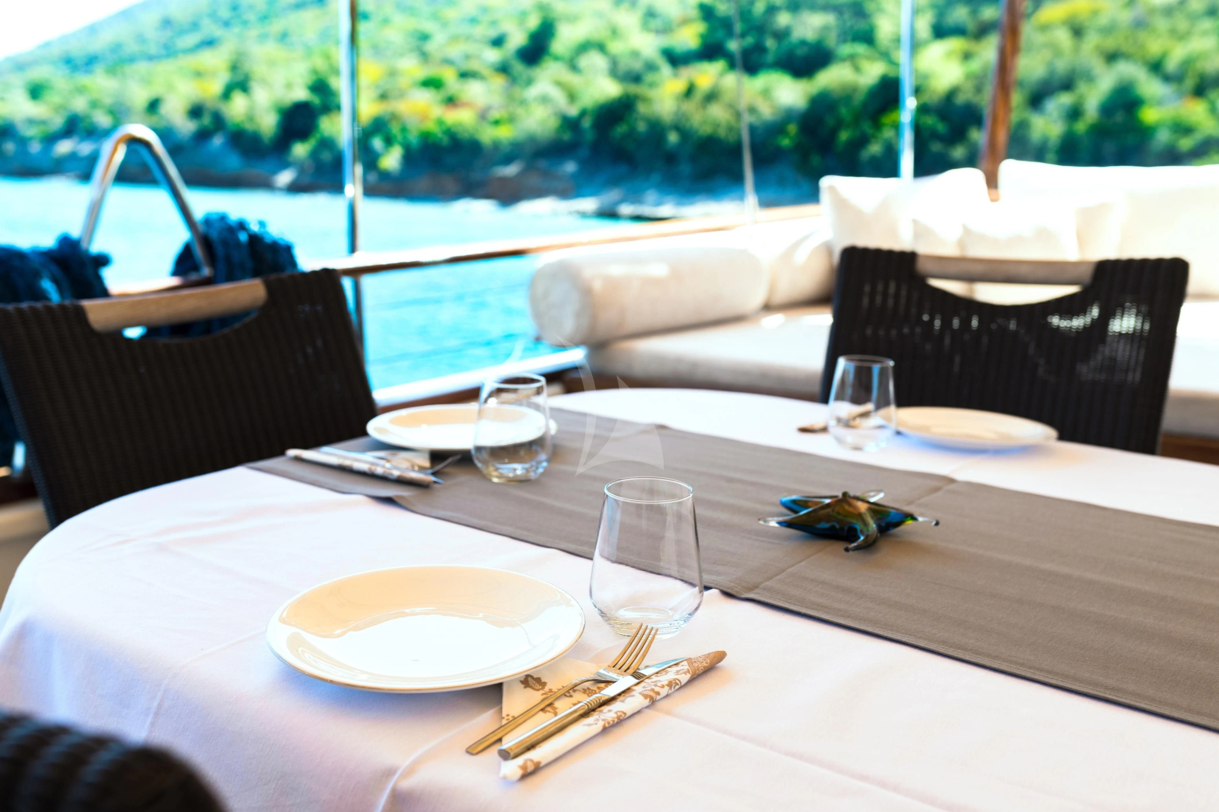 a table with plates and glasses on it aboard DOUBLE EAGLE Yacht for Sale