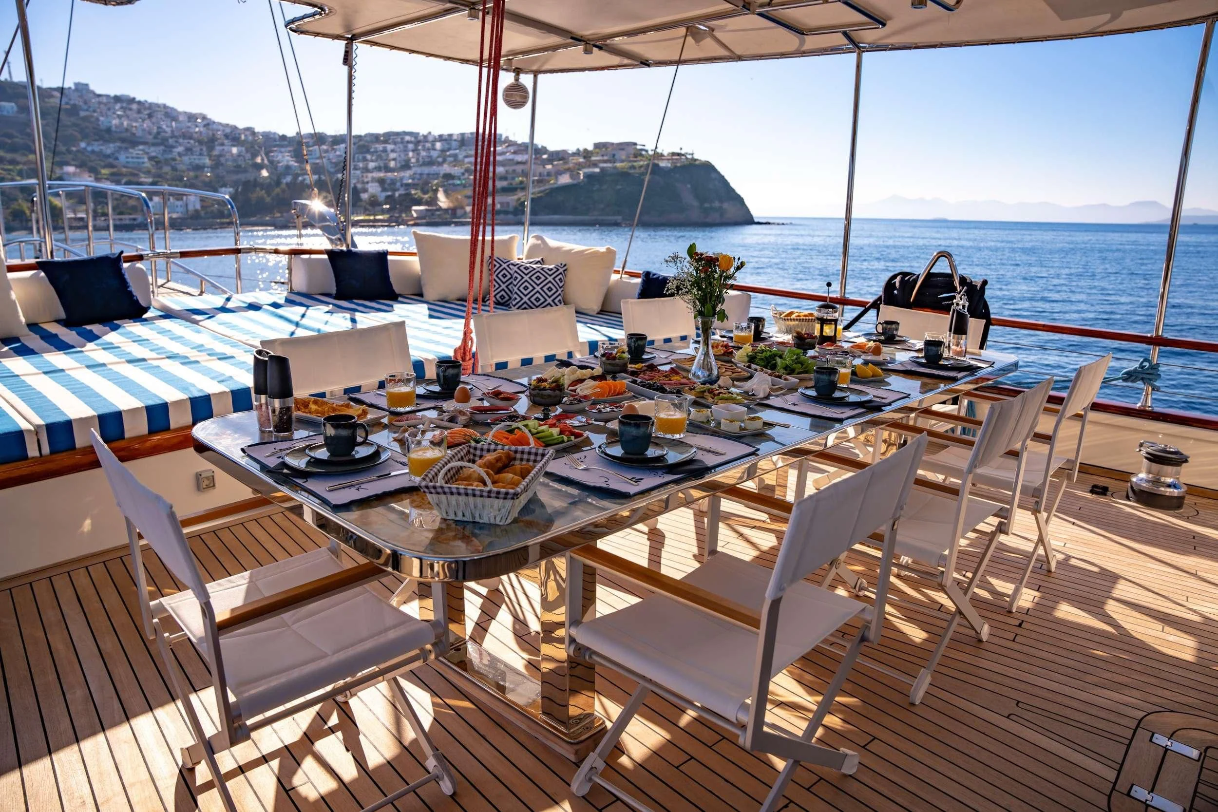 a table with chairs and a large body of water in the background aboard DOUBLE EAGLE Yacht for Sale