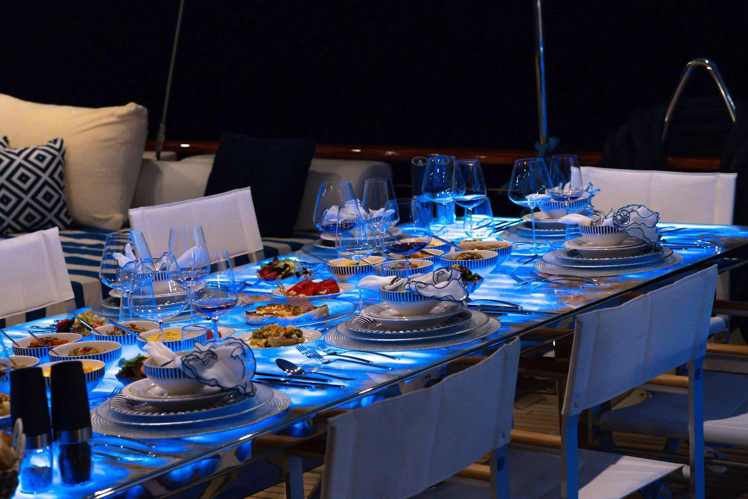 a table with plates and glasses on it aboard DOUBLE EAGLE Yacht for Sale
