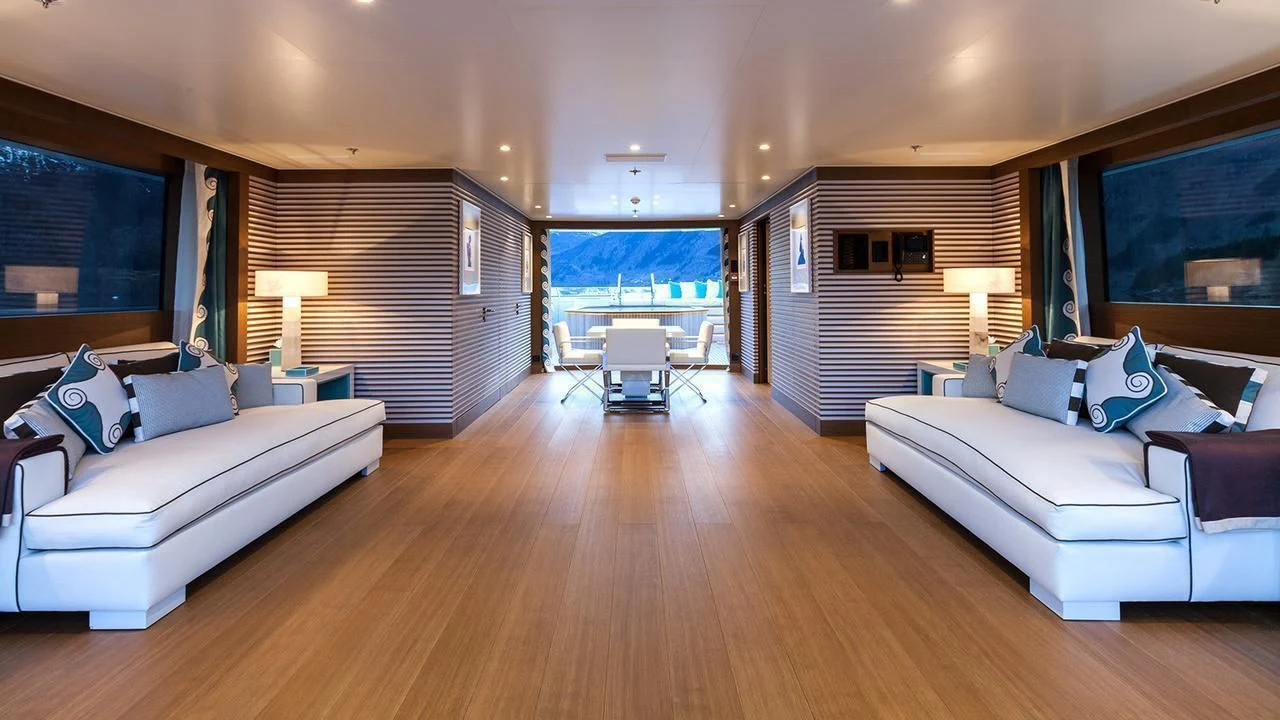 a living room with a large wood floor and a large window aboard EVENT Yacht for Sale