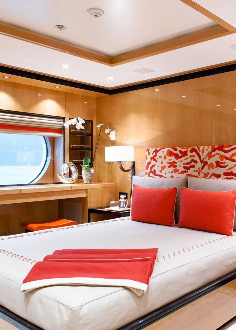 a bed with red pillows aboard EVENT Yacht for Sale