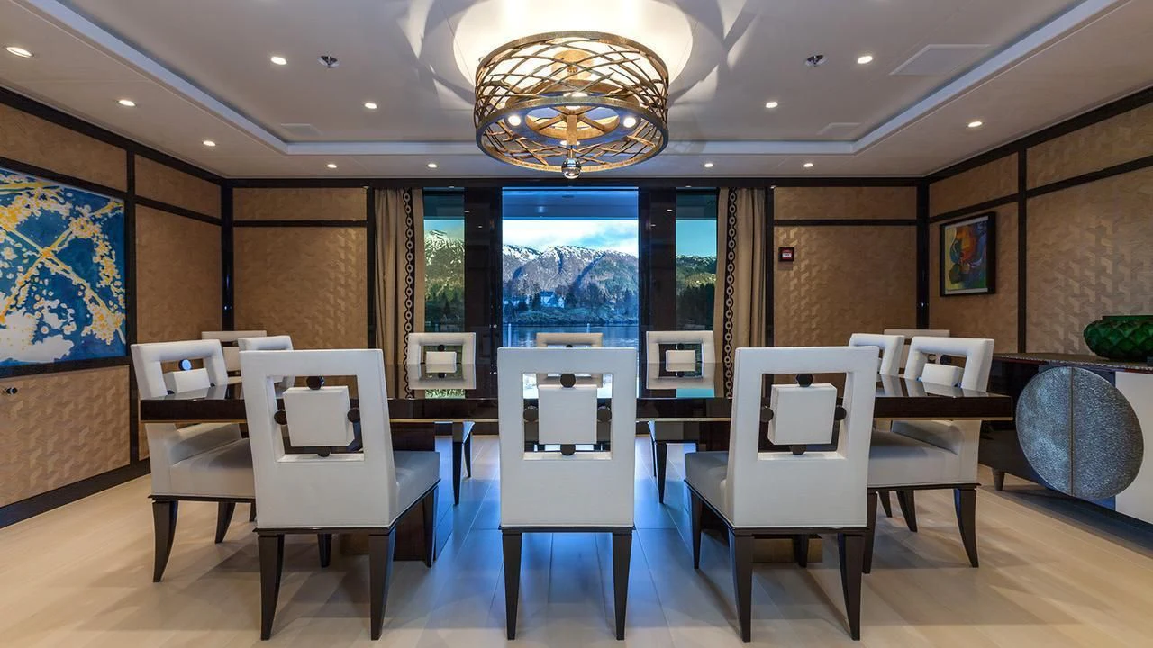 a room with tables and chairs aboard EVENT Yacht for Sale