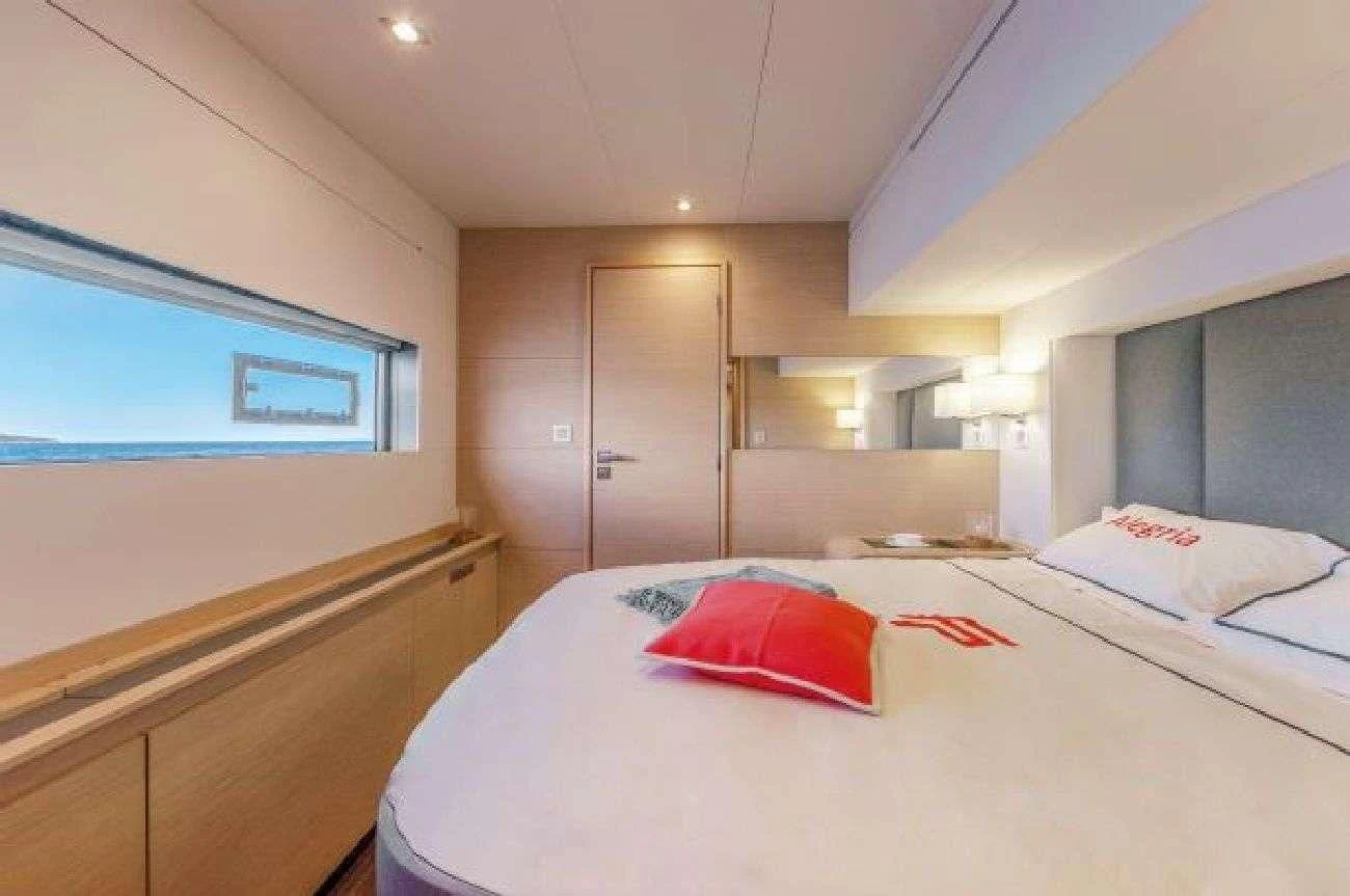 a bedroom with a bed and a window aboard AETHER Yacht for Charter