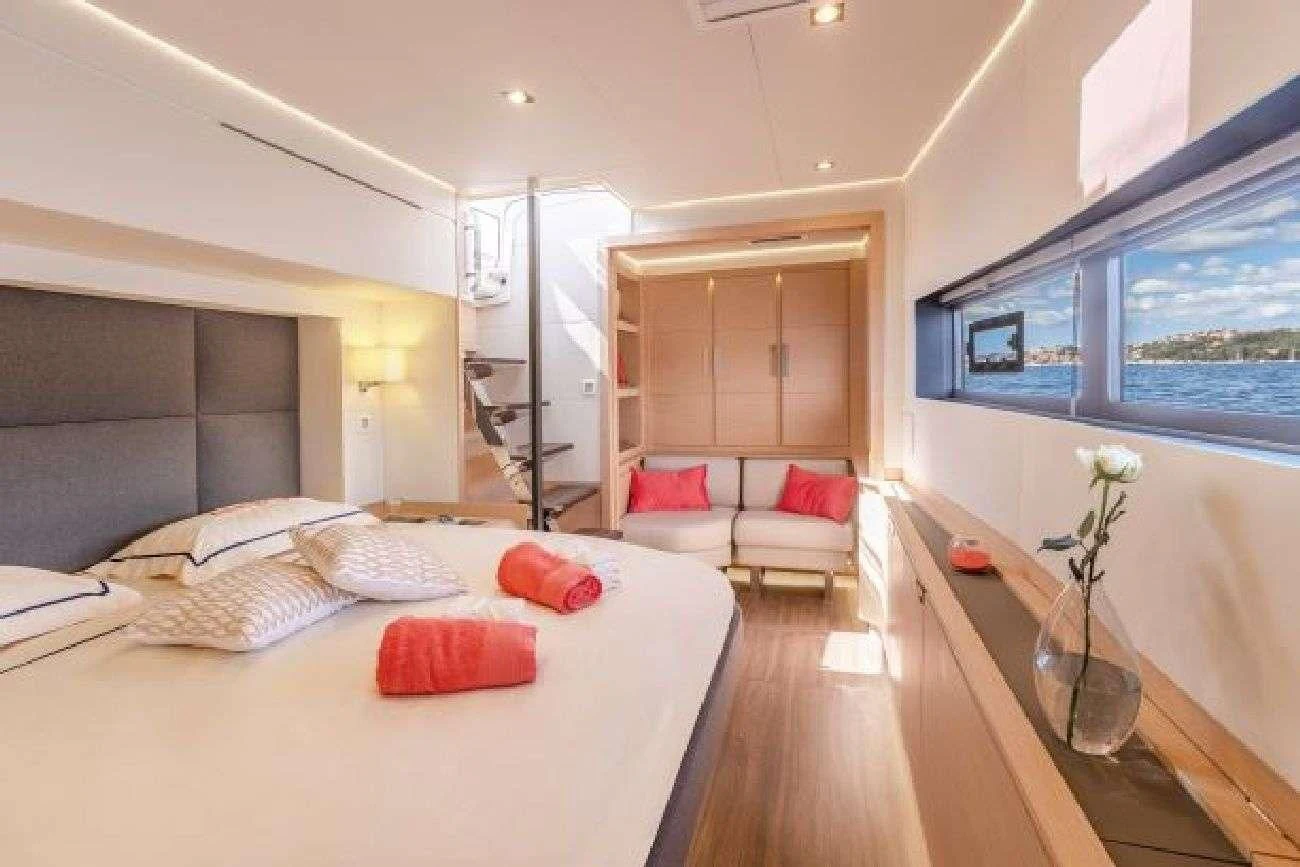 a bedroom with a bed and a table aboard AETHER Yacht for Charter