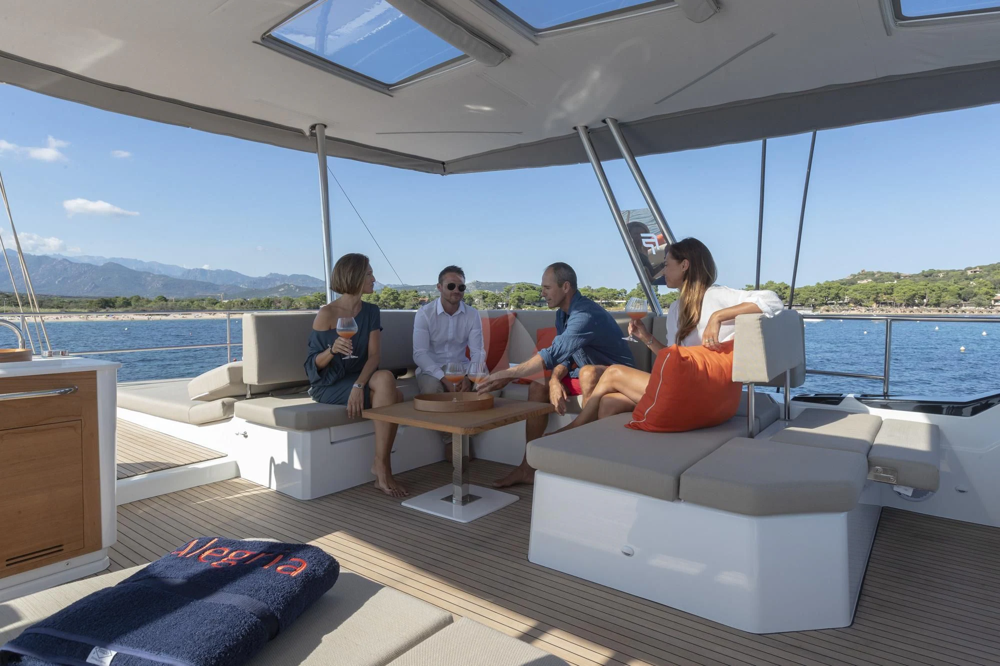 a group of people sitting around a table on a boat aboard AETHER Yacht for Charter