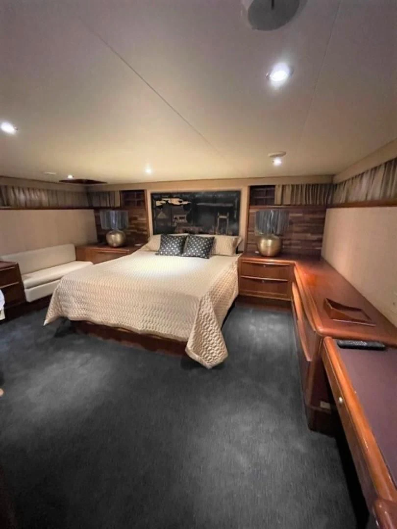 a bedroom with a bed and desk aboard MR. ED Yacht for Sale