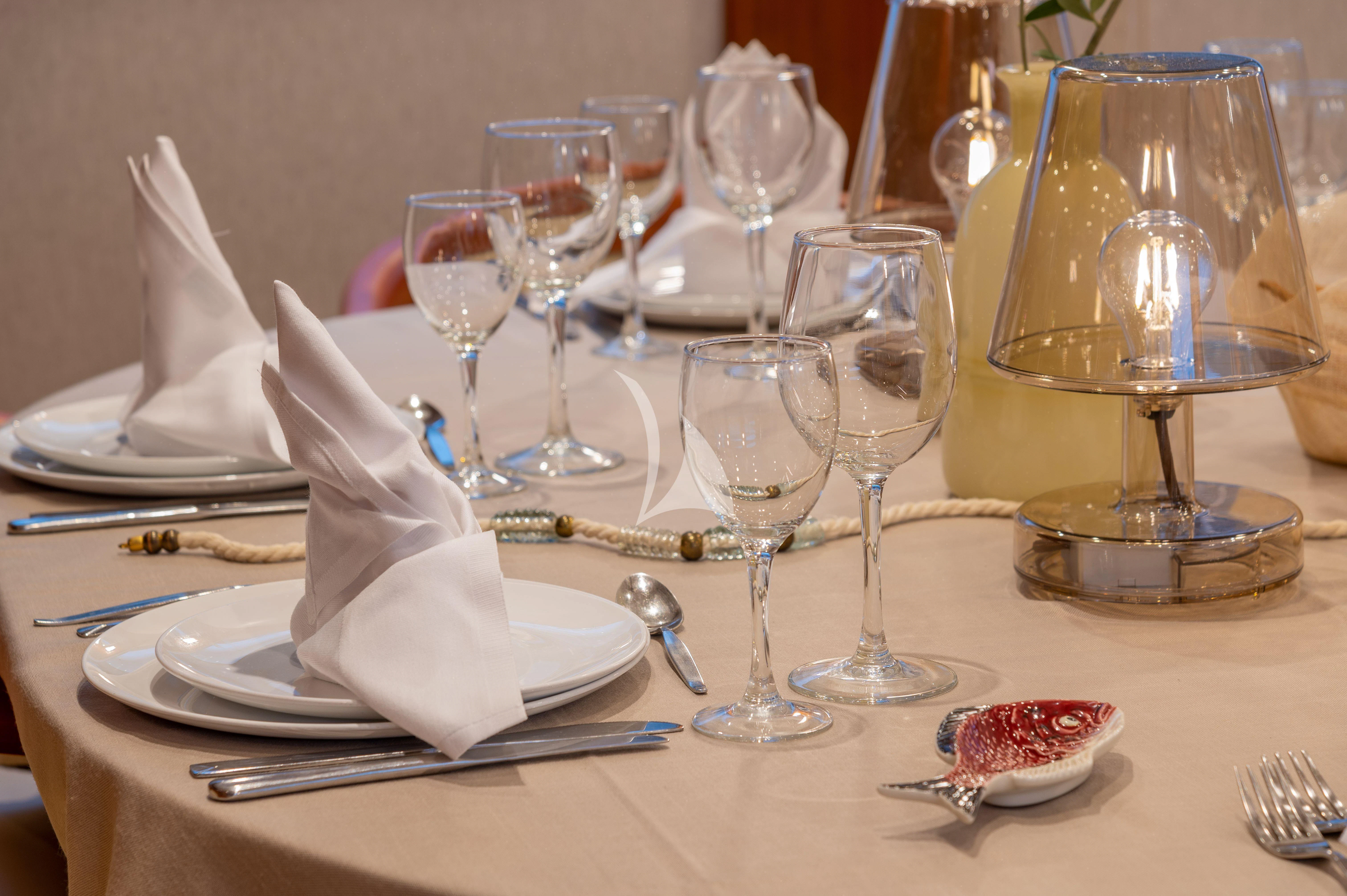 a table with wine glasses and food aboard TAKA Yacht for Sale