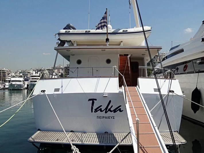 a large white boat in a harbor aboard TAKA Yacht for Sale