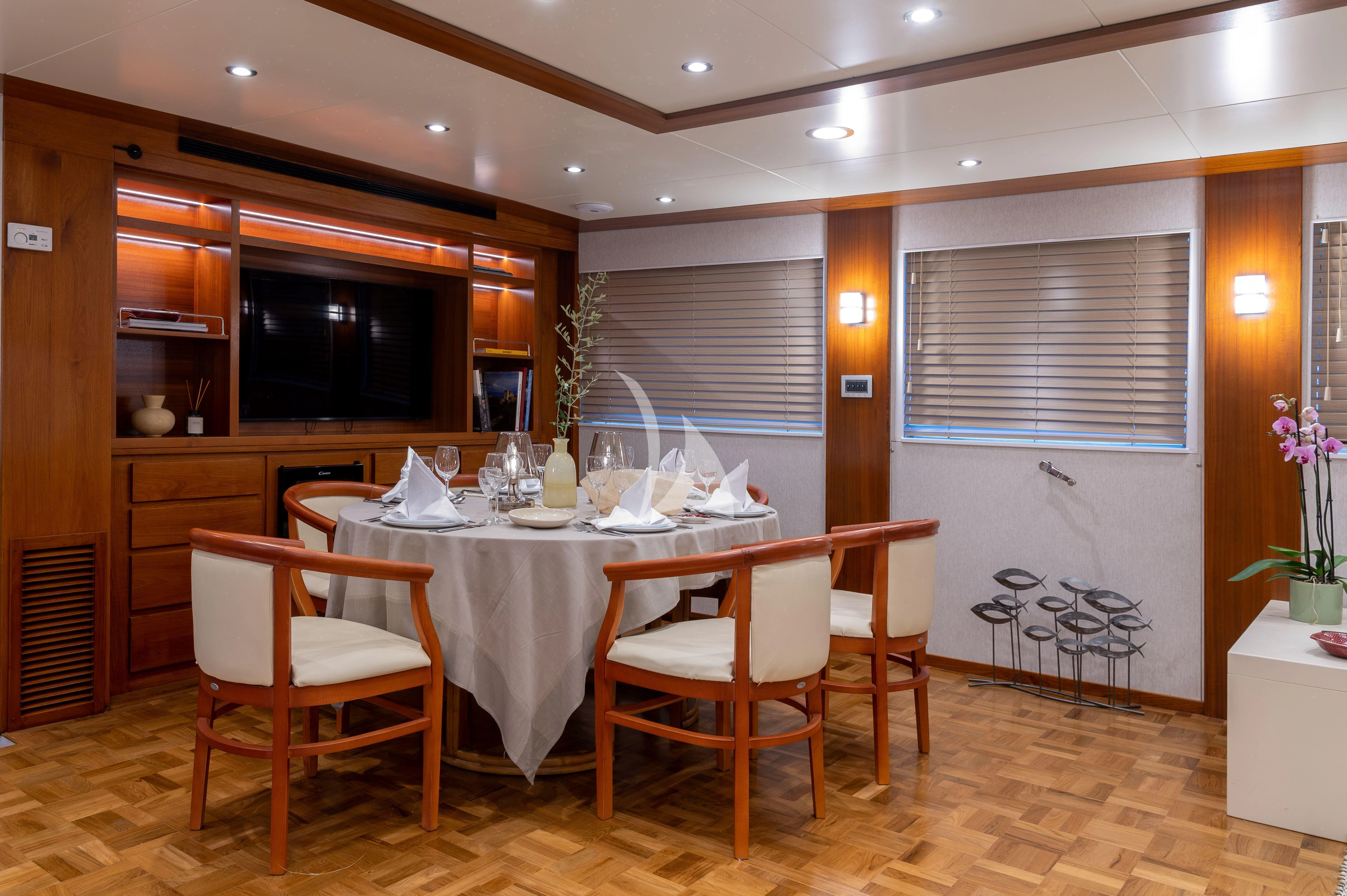 a dining table and chairs in a kitchen aboard TAKA Yacht for Sale