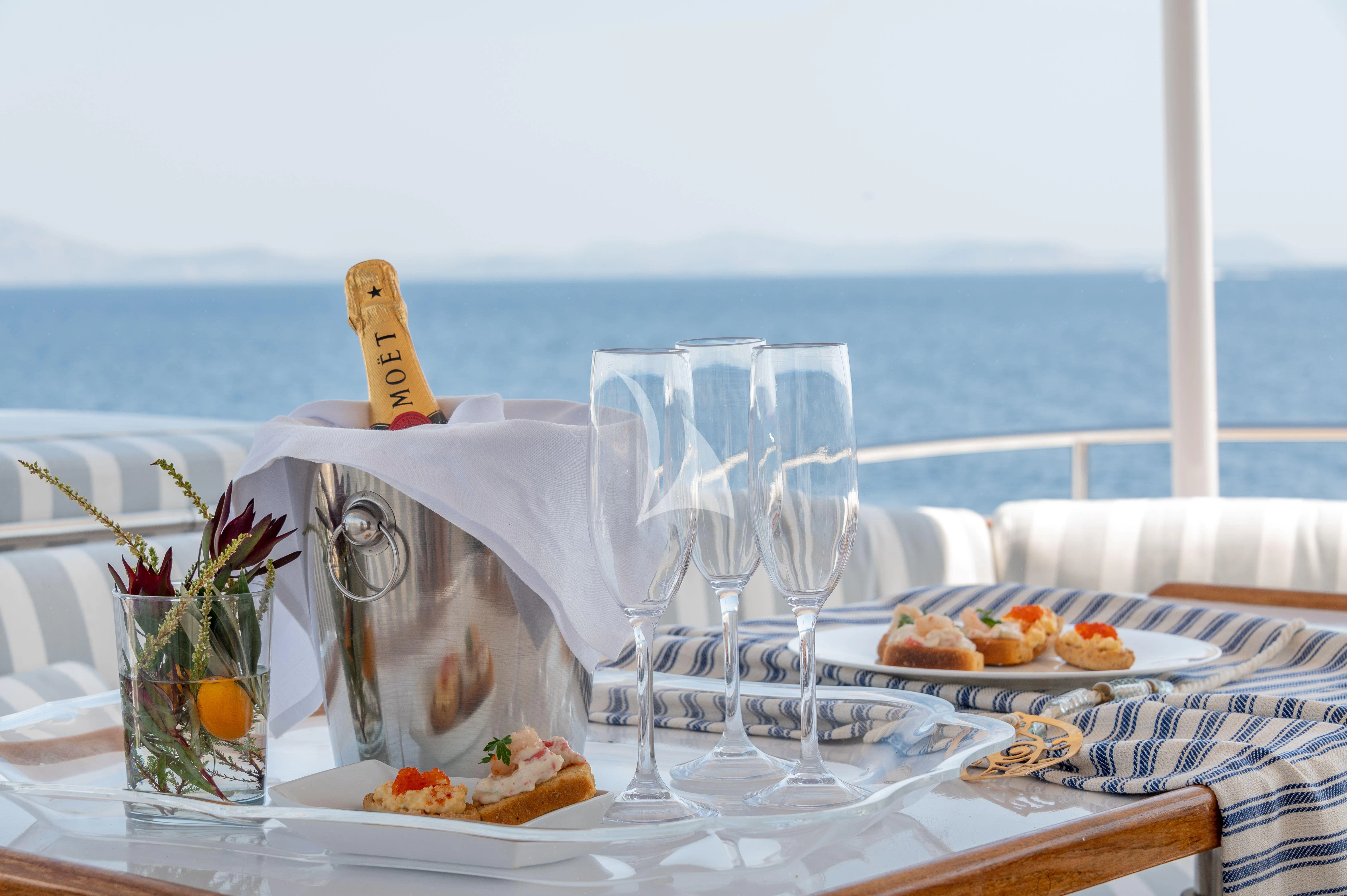 a table with food and glasses on it aboard TAKA Yacht for Sale