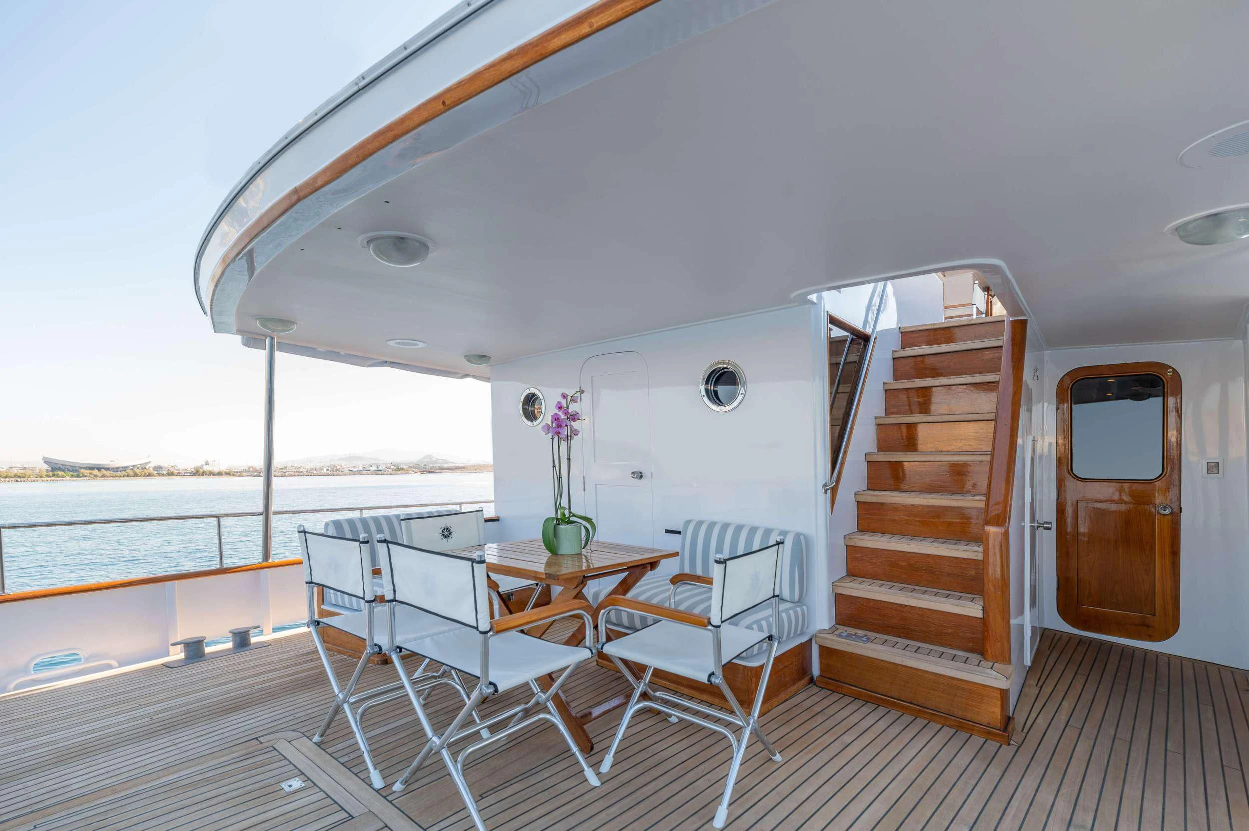 a white tent with a table and chairs and a railing aboard TAKA Yacht for Sale