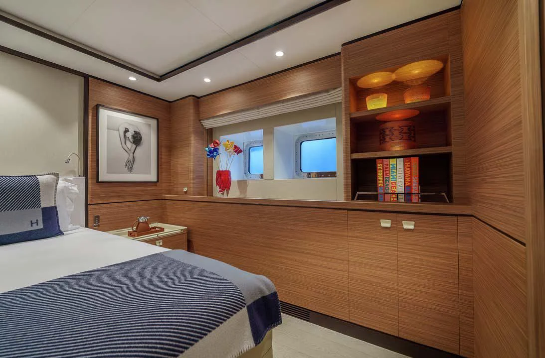 a room with a bed and a shelf with books on it aboard SEA EAGLE Yacht for Sale