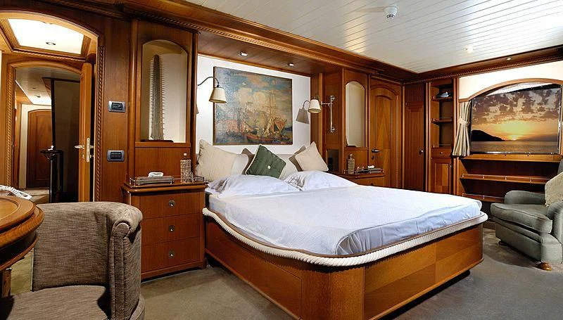 a bedroom with a bed and a chair aboard MESERRET Yacht for Sale