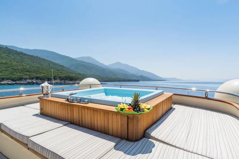 a deck with a large body of water and a large mountain in the background aboard MESERRET Yacht for Sale