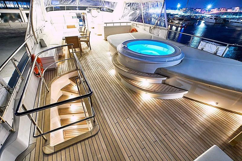 a deck with a pool and a deck with a view of a city at night aboard BLUE BERRY Yacht for Sale