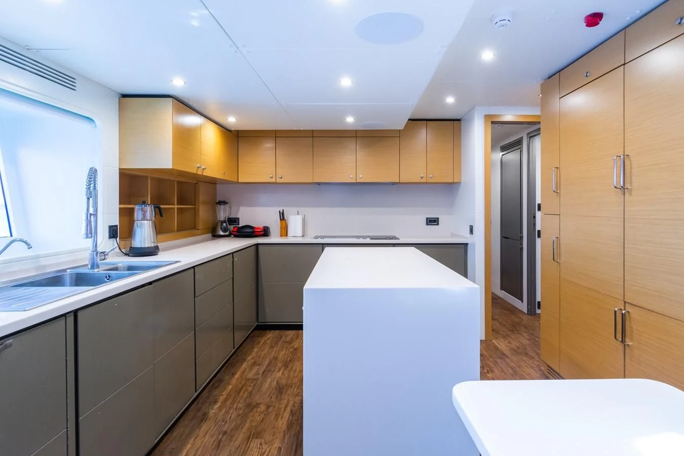 a kitchen with a white counter and wooden cabinets aboard LEONIDAS Yacht for Sale