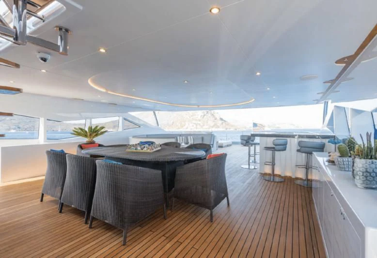 a large room with a table and chairs and a large pool aboard LEONIDAS Yacht for Sale