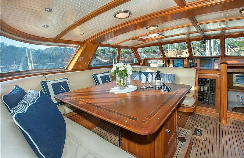 a large table with a couch and a vase of flowers on it aboard AUDREY II Yacht for Sale