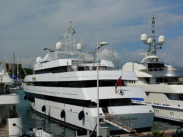 a large white boat sits in a harbor aboard SHAHNAZ Yacht for Sale