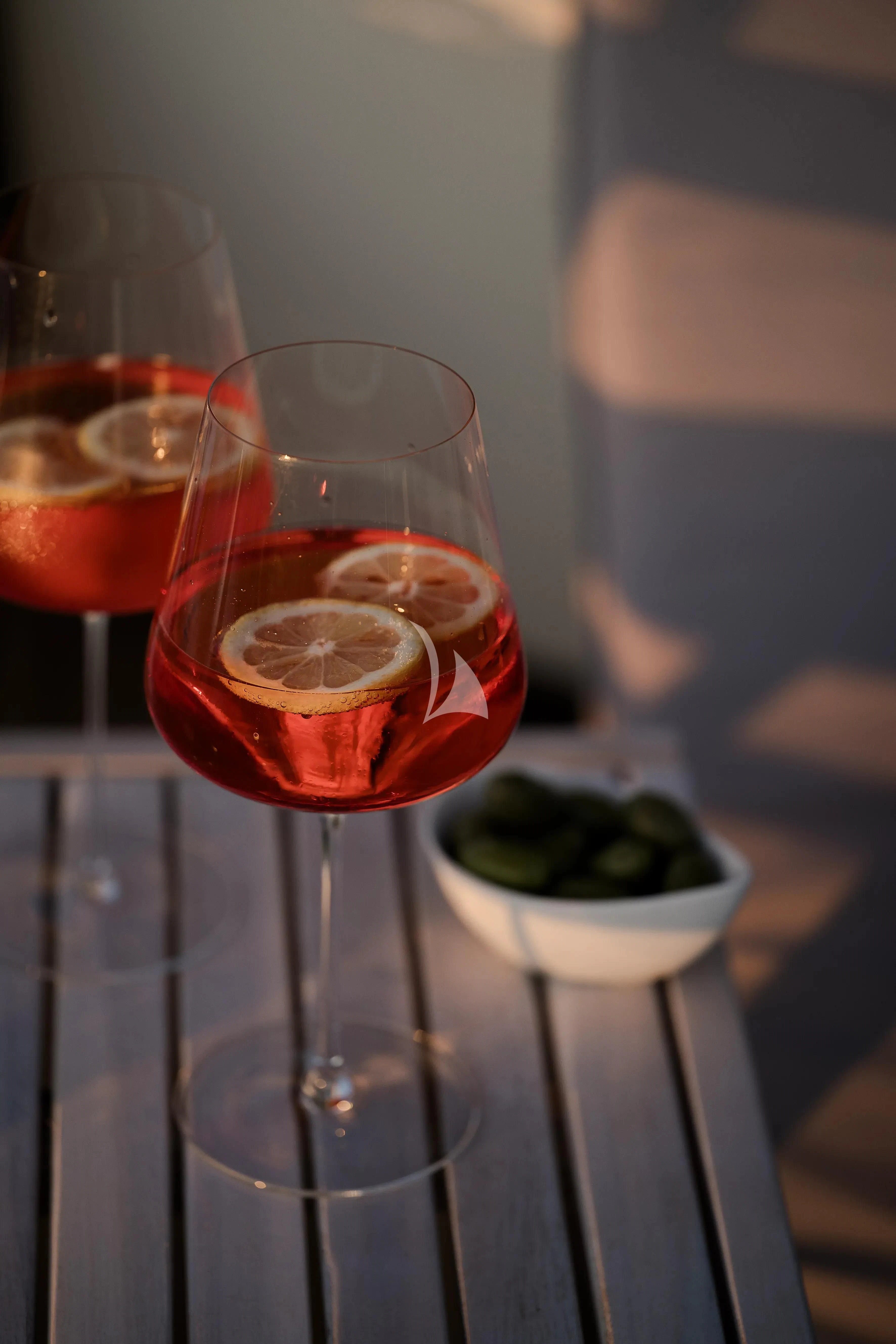 a glass of wine and a bowl of fruit on a table aboard OCEAN DELTA 11 Yacht for Sale