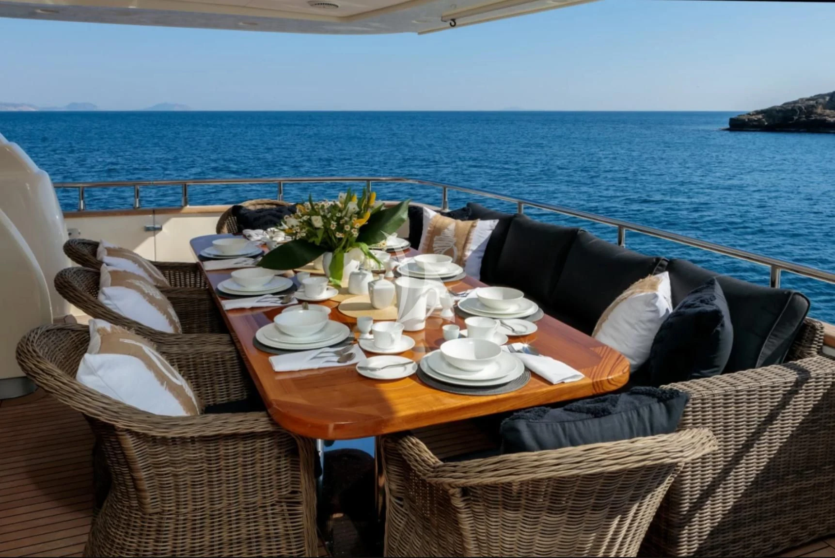 a table with plates and chairs on it next to a body of water aboard OCEAN DELTA 11 Yacht for Sale