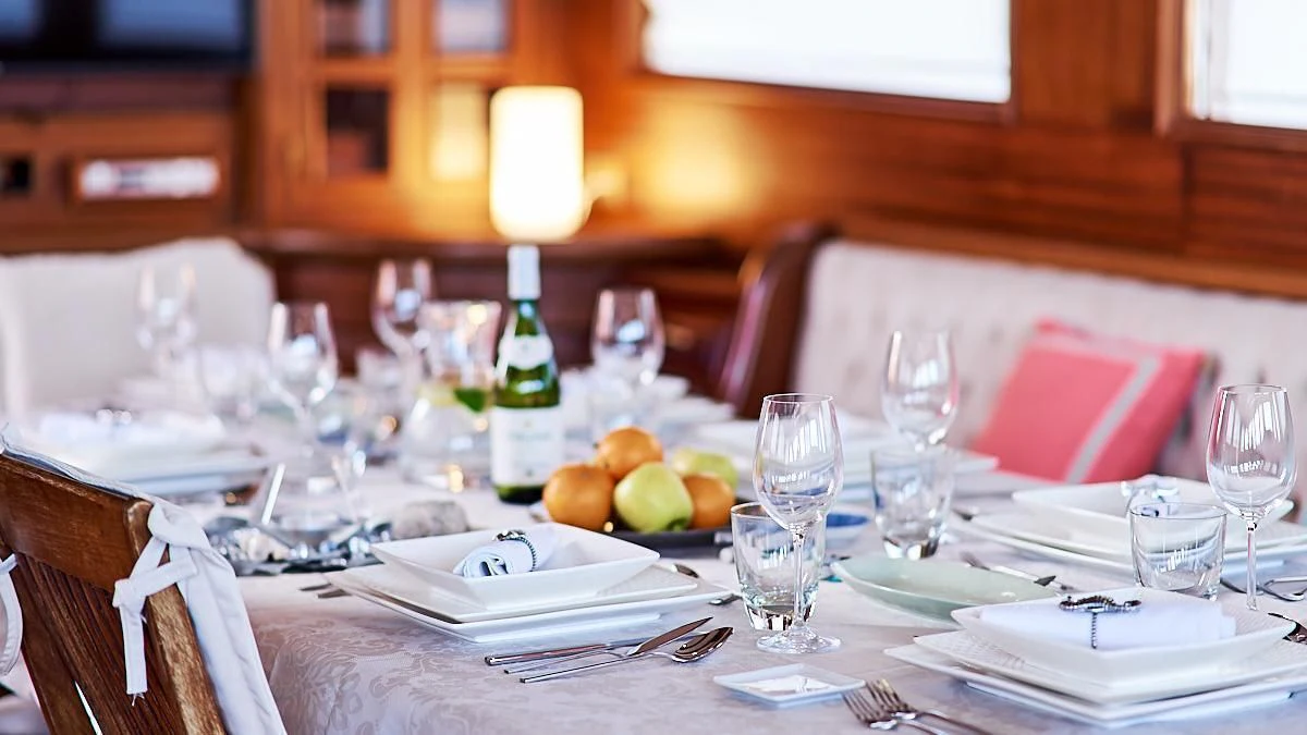 a table with plates and glasses aboard QUEEN OF KARIA Yacht for Sale