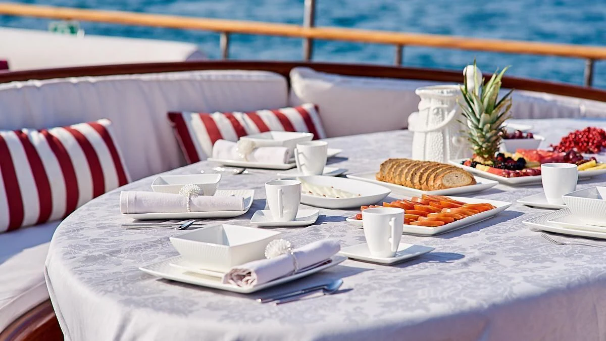 a table with plates and food on it aboard QUEEN OF KARIA Yacht for Sale