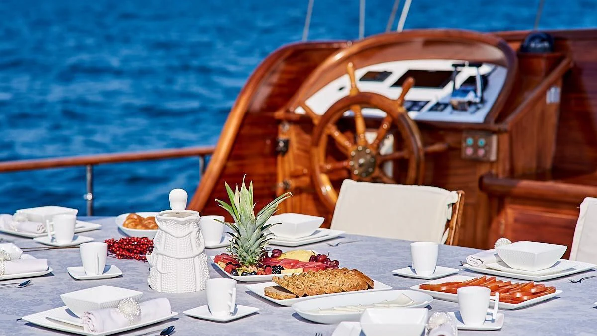 a table with food and a wheel on it aboard QUEEN OF KARIA Yacht for Sale